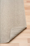 Light brown textured area rug with woven border and corner detail