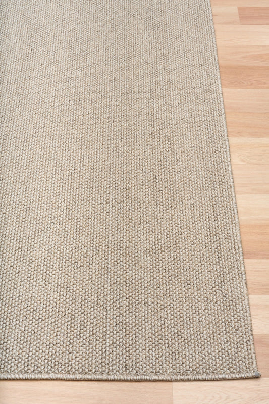 Light brown textured area rug edge with tight flat border stitching