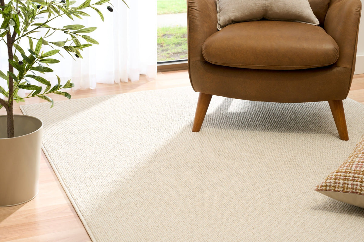 Cream woven area rug with visible loop texture and finished edge