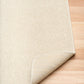 Cream woven area rug with short textured pile and neatly finished edge