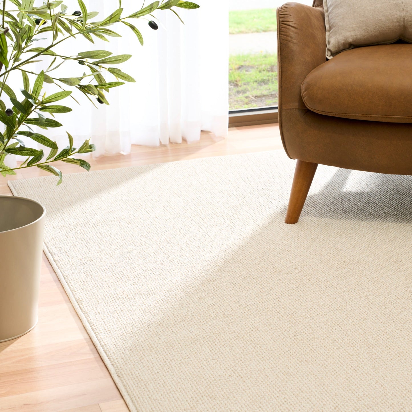 Cream woven area rug spanning the floor with textured loop weave visible