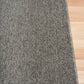 Grey woven area rug with a neat selvage border