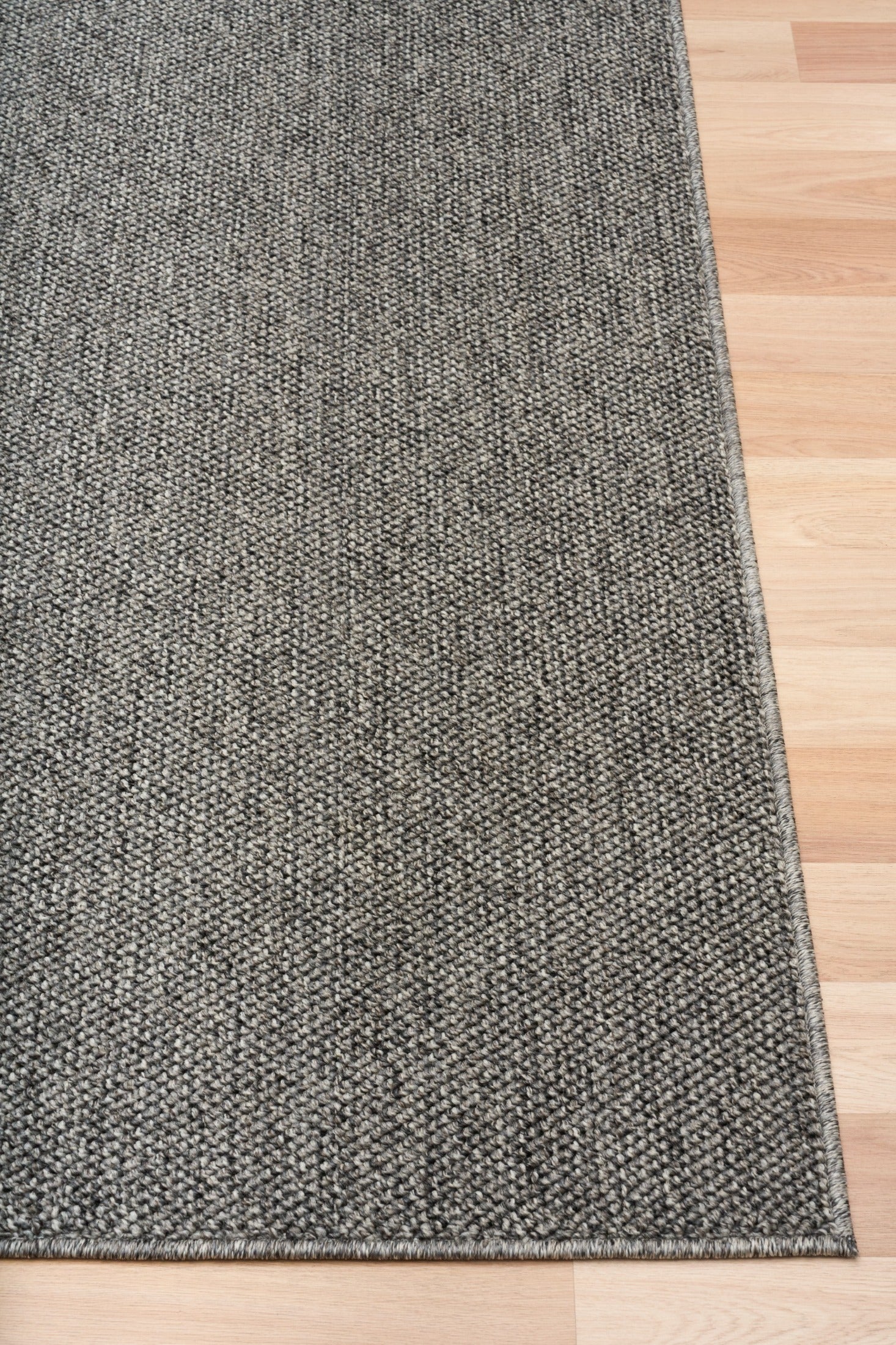 Grey woven area rug with a neat selvage border
