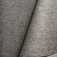 Grey woven area rug with stitched binding detail along the edge