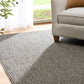 Grey woven area rug on light wood floor