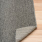 Grey area rug with light stitched edge on the corner
