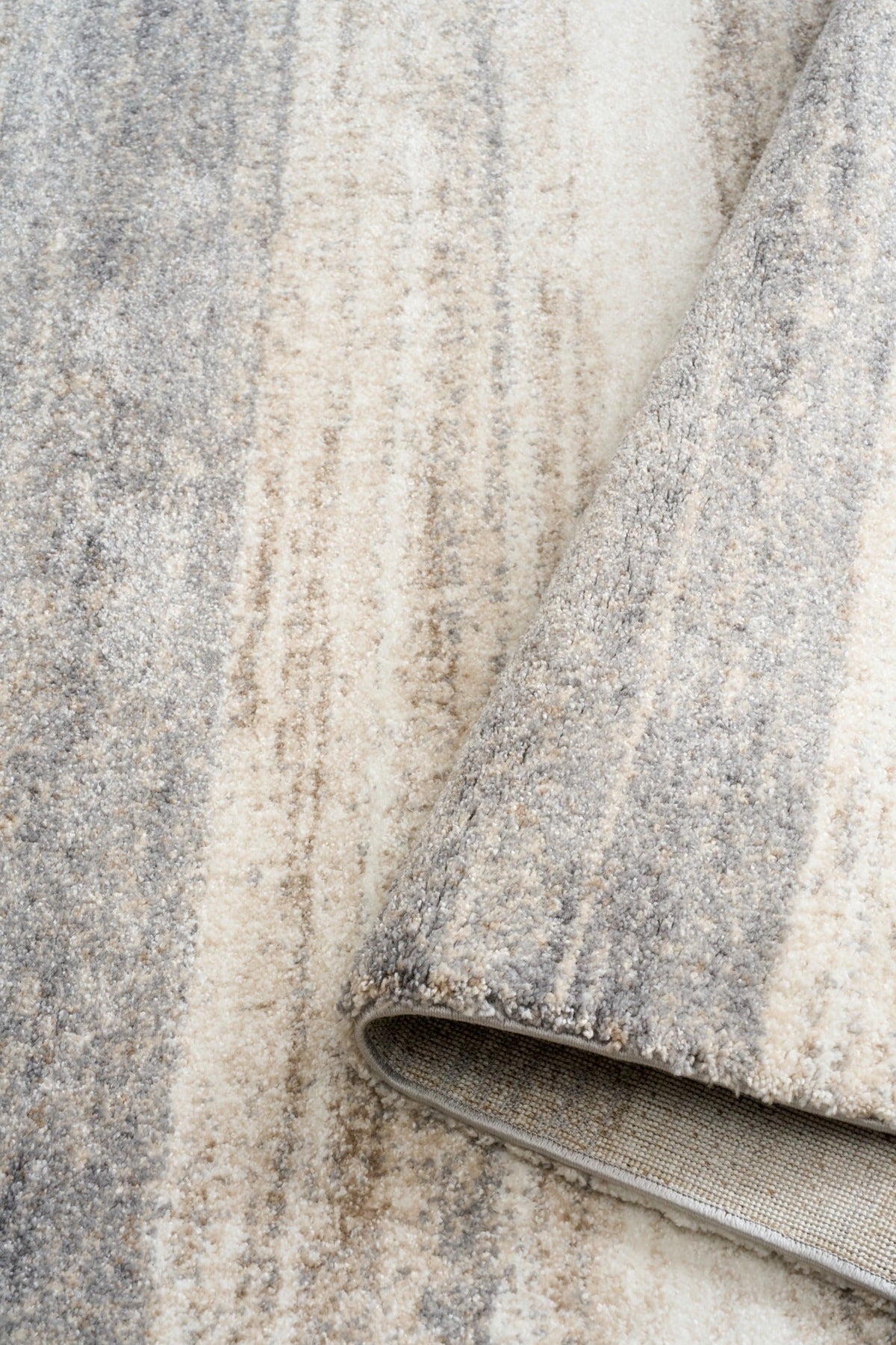 Bone grey rug fabric close-up with bound edge and fine mottled texture