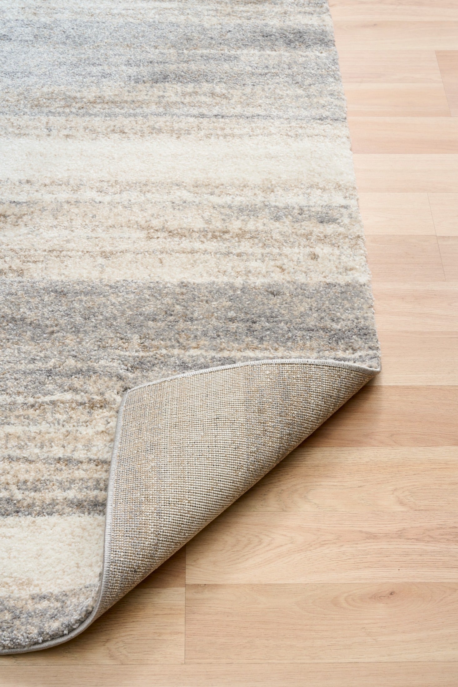Bone grey rug corner showing backing and bound border detail
