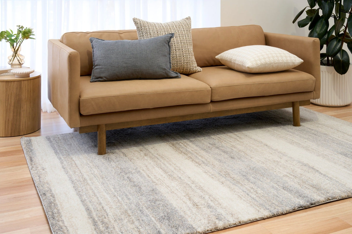 Bone grey striped area rug in living room on light wood flooring