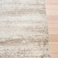 Bone cream area rug corner with short textured pile and distressed pattern