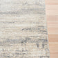 Grey and cream abstract area rug with short textured pile and visible border edge