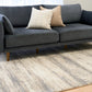 Grey and cream abstract area rug under living room seating, low-pile woven texture