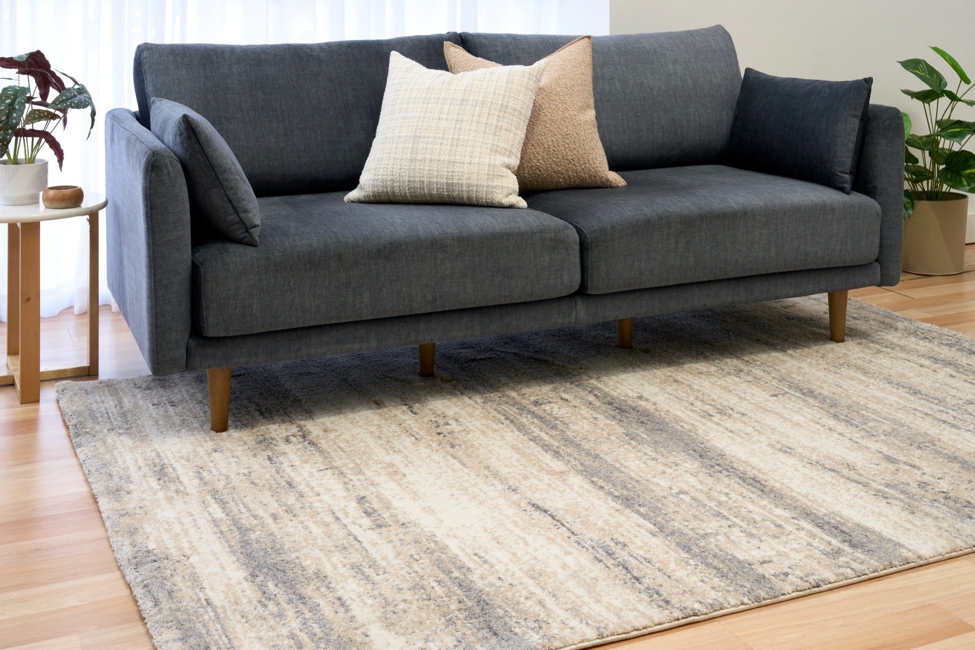 Grey and cream abstract area rug under living room seating, low-pile woven texture
