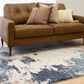 Rectangular area rug with distressed blue, cream, and rust abstract pattern