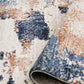 Close-up of rug pile texture with distressed cream, navy blue, and rust speckles