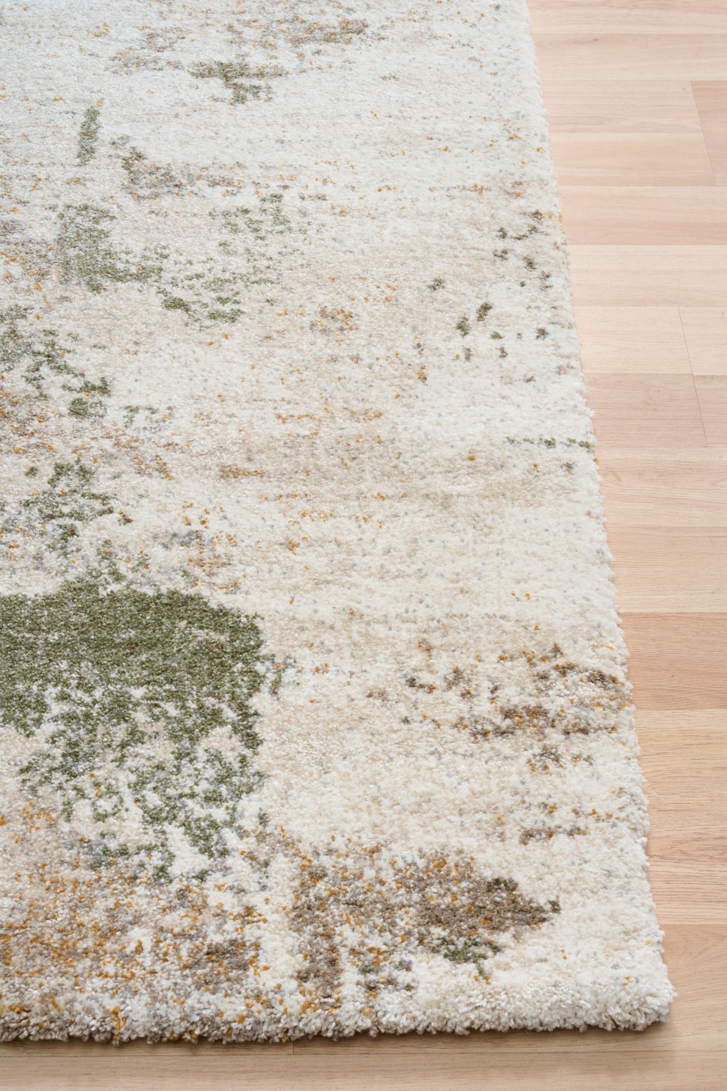 Green and cream abstract textured area rug corner with low pile edge binding