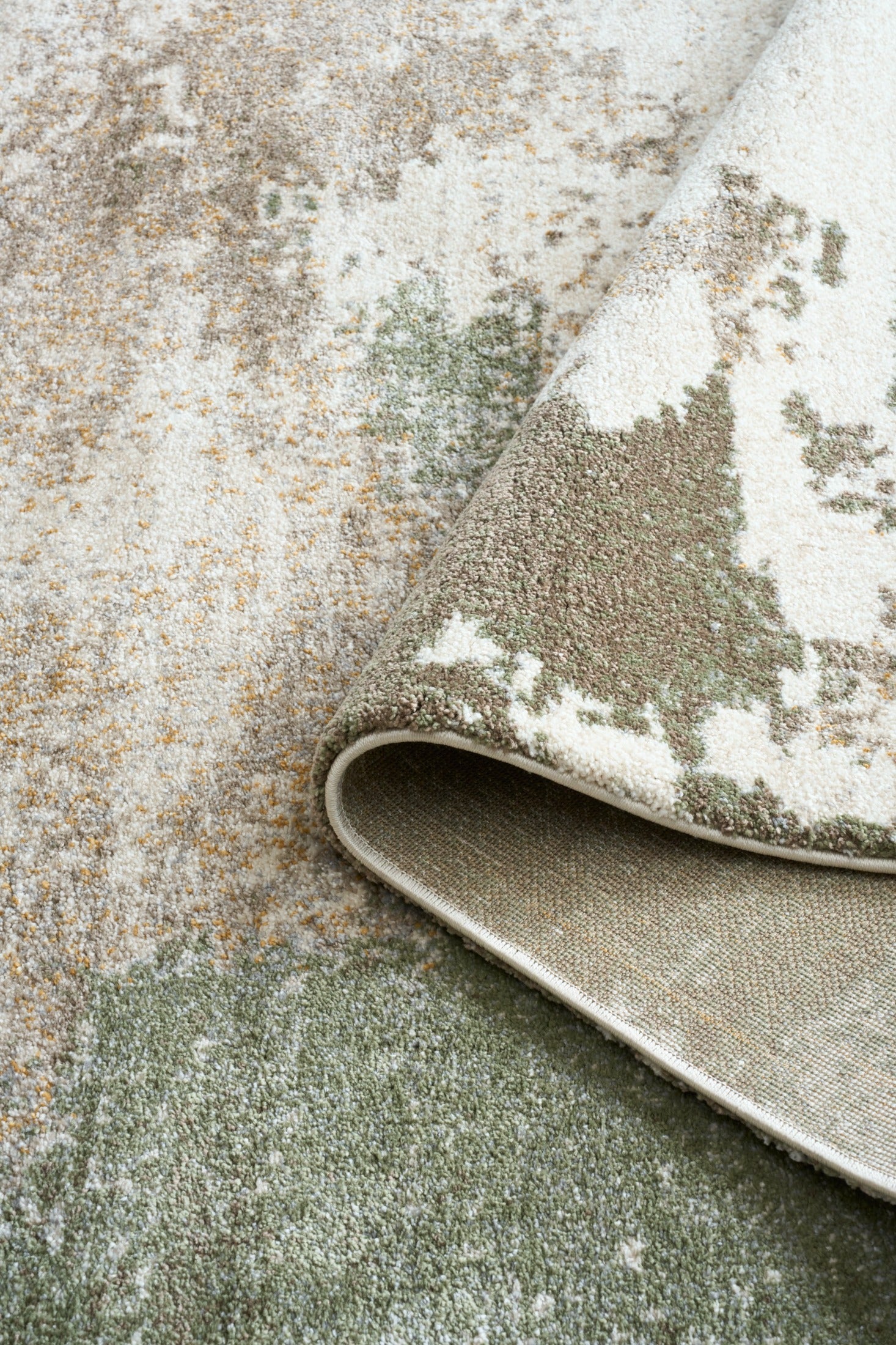 Green and cream abstract area rug with bound edge detail and textured pile