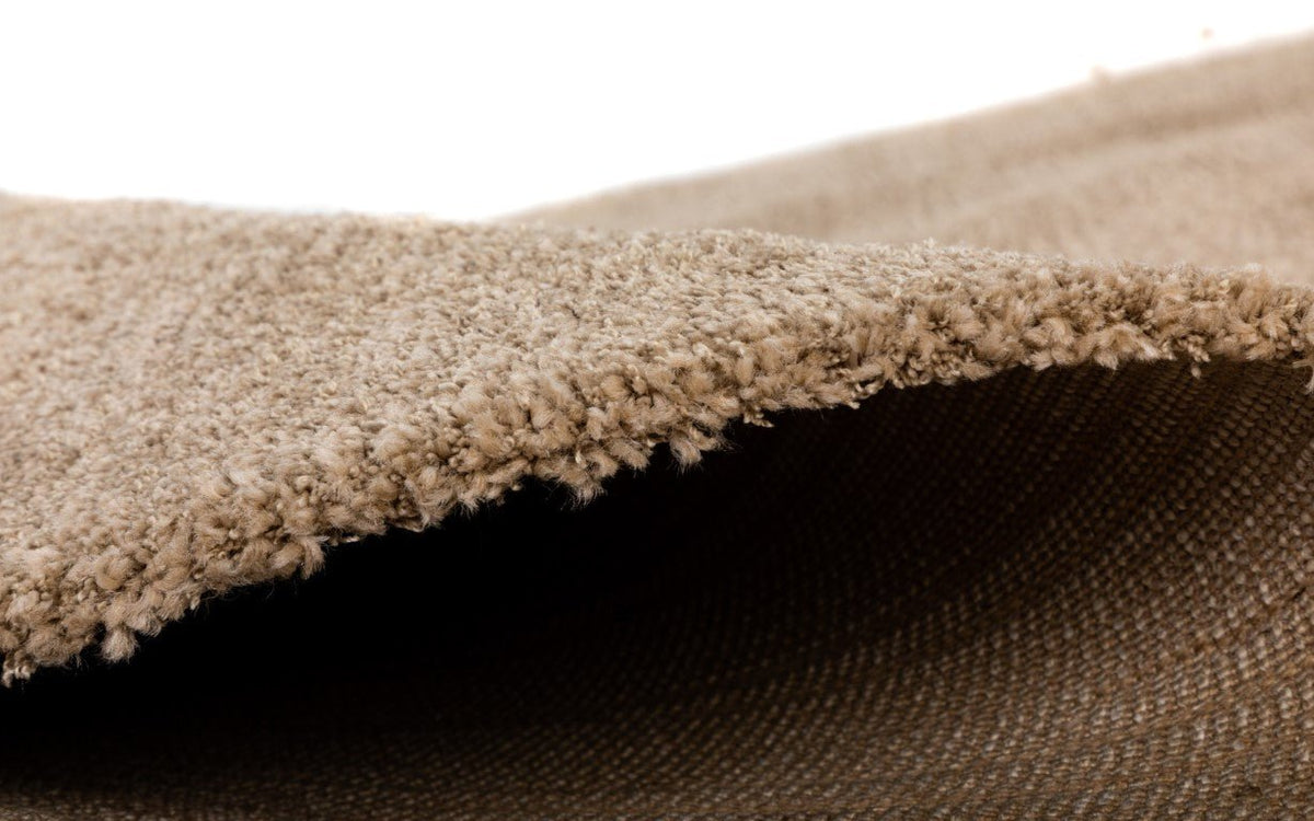Beige rug with thick textured pile edge and underside weave