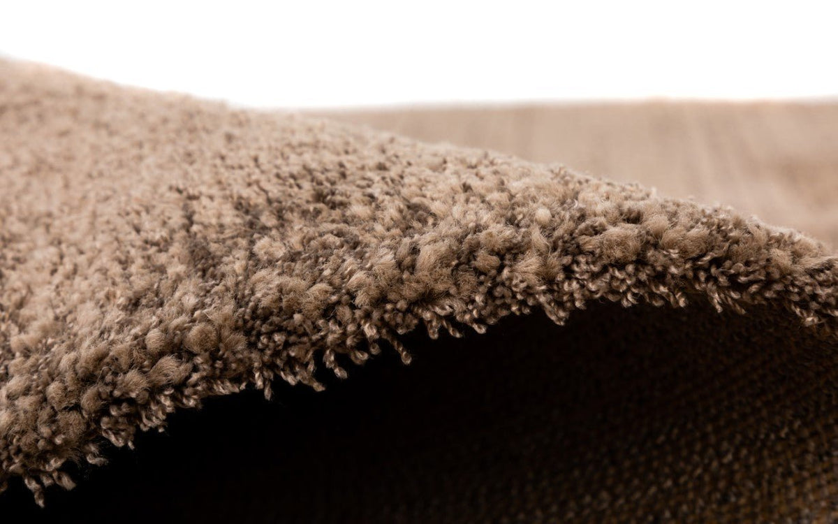 Thick brown rug pile at edge, plush shag detail.