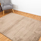Taupe-brown area rug with dense low pile texture.