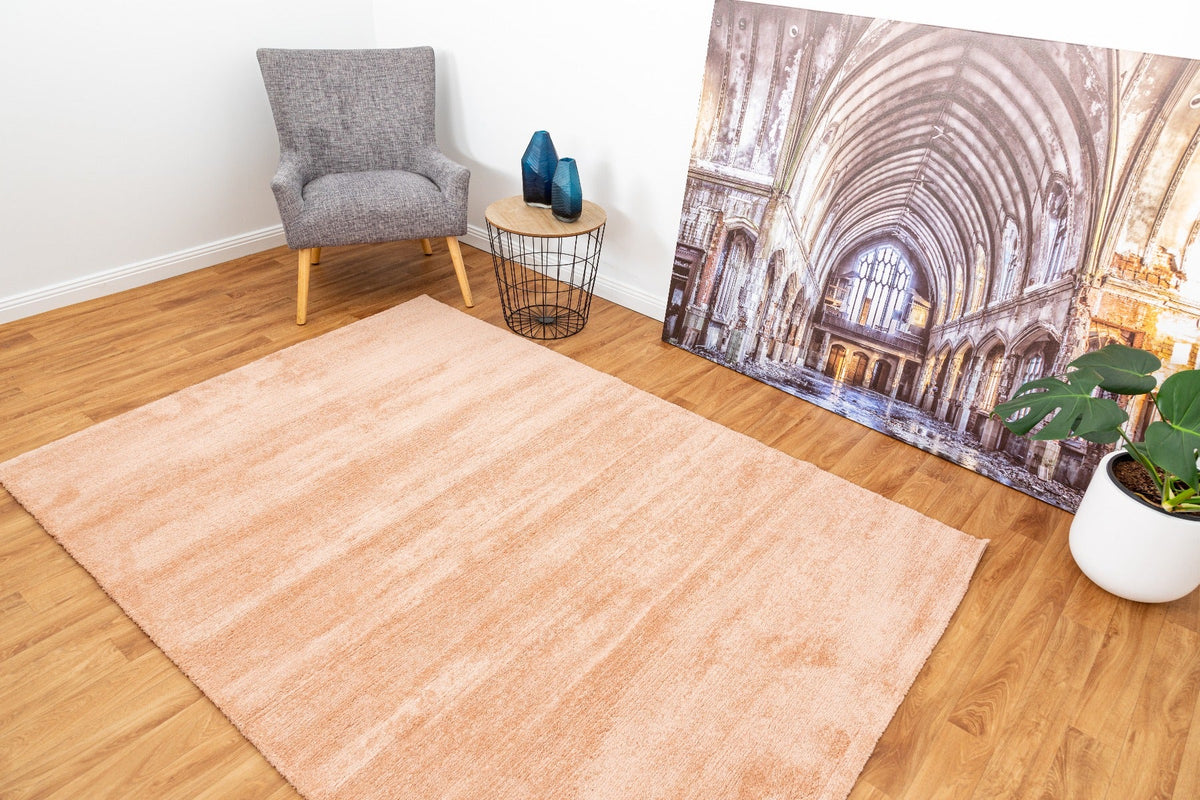 Peach area rug with short textured pile and rectangular shape