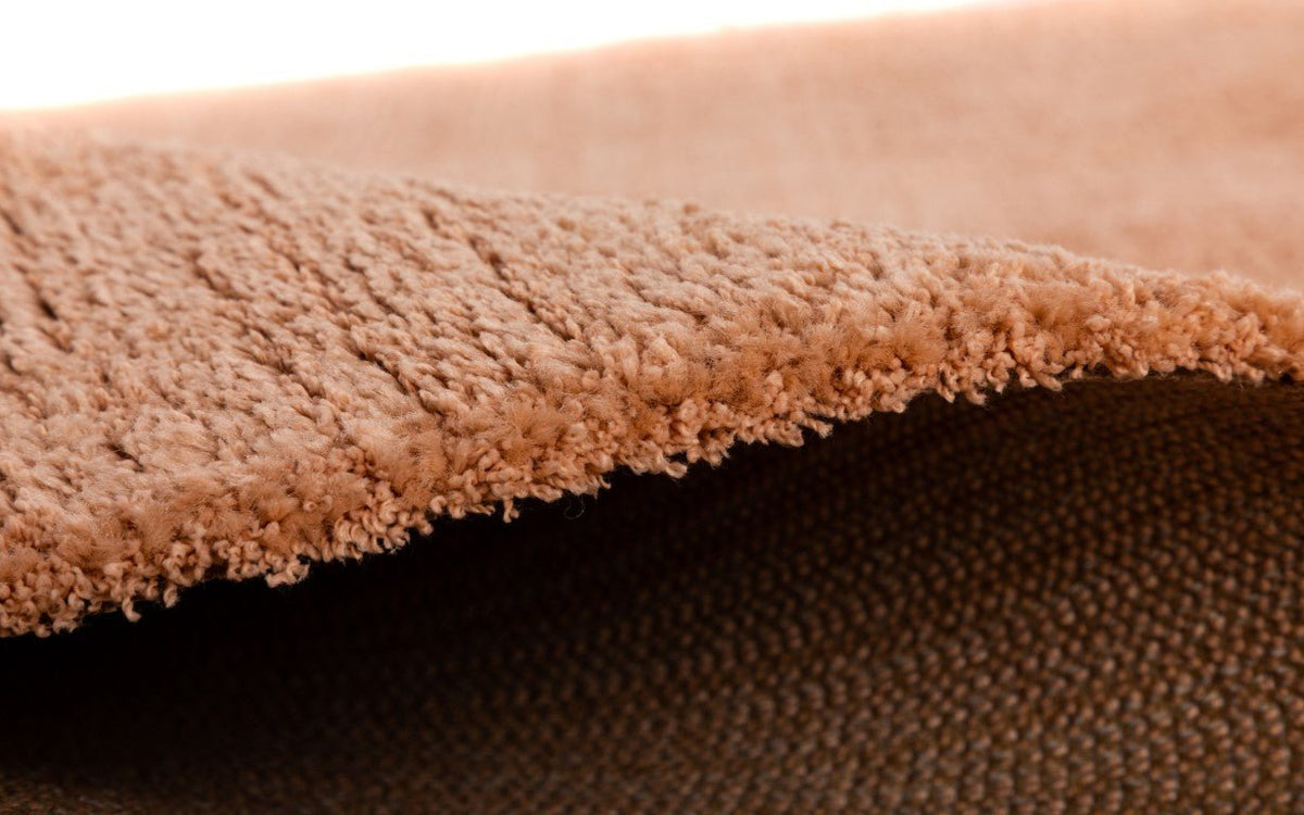 Peach rug pile edge close-up with low cut textured surface