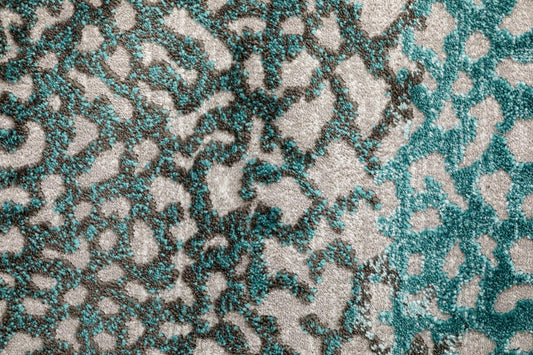 Grey and teal abstract rug texture with scattered geometric motifs.