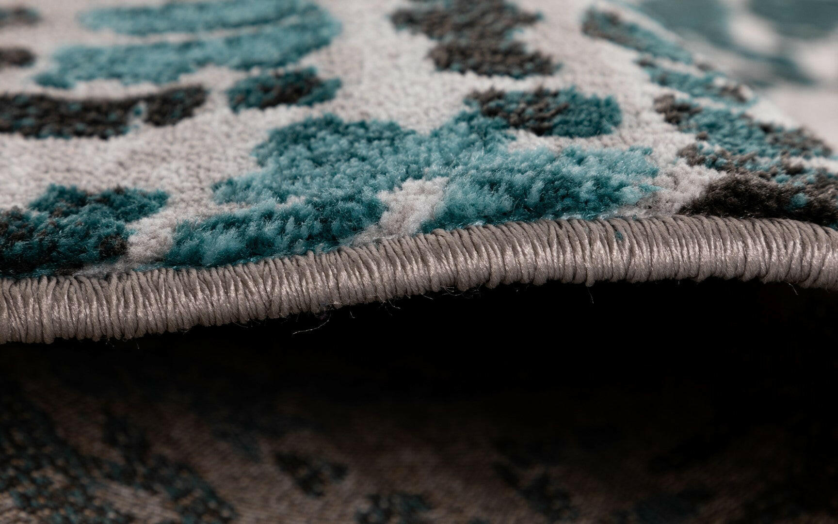 Grey-blue abstract area rug binding on edge, thick pile texture