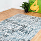 Modern abstract floor rug with teal and blue blocks on a light background