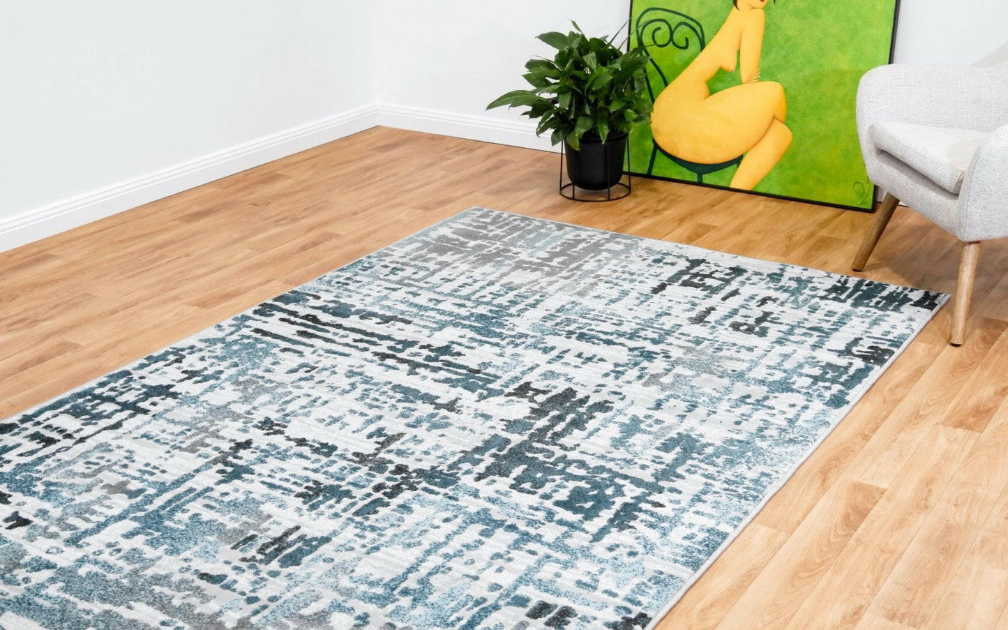 Modern abstract floor rug with teal and blue blocks on a light background