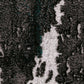 Close-up of gray and white distressed abstract rug pattern with speckled details