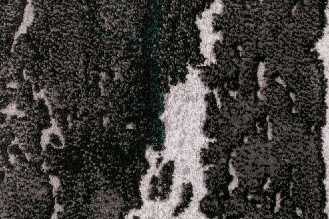 Close-up of gray and white distressed abstract rug pattern with speckled details