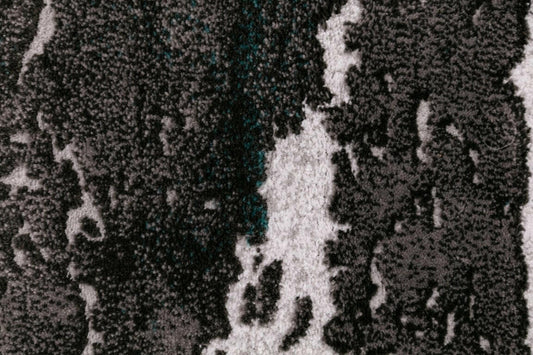 Close-up of gray and white distressed abstract rug pattern with speckled details