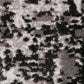 Close-up of abstract rug texture with dark and light mottled speckle design.