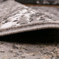 Rug pile edge detail showing curved binding and thick low-profile construction.