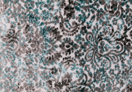 Grey and teal-blue rug surface with intricate speckled ornamental motifs