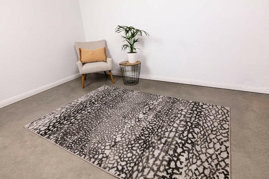 Timeless grey area rug with black speckled geometric pattern and flat weave design