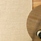Cream wool rug corner with tightly woven, textured surface and looped fibers