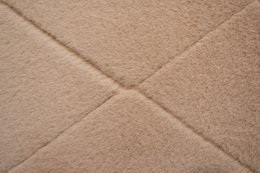 Soft pink shag rug close-up with diamond texture and stitched seam