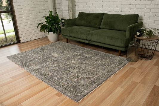 Grey distressed area rug with ornate medallion pattern, rectangular