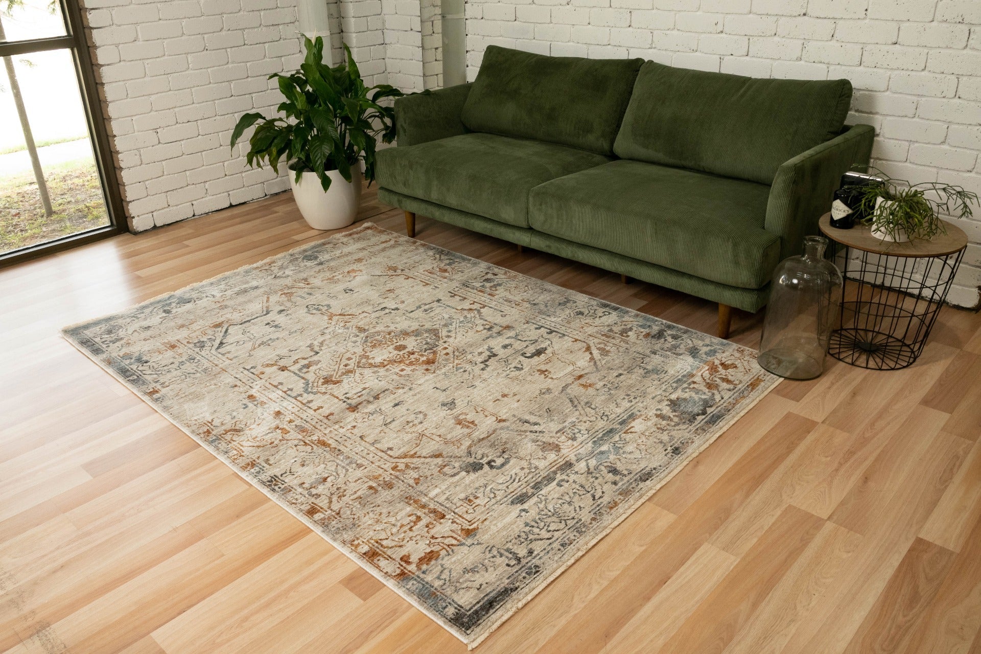 Distressed multi-color area rug with central medallion and ornate border on light base