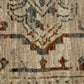 Close-up of distressed area rug pattern with light base, blue and rust accents